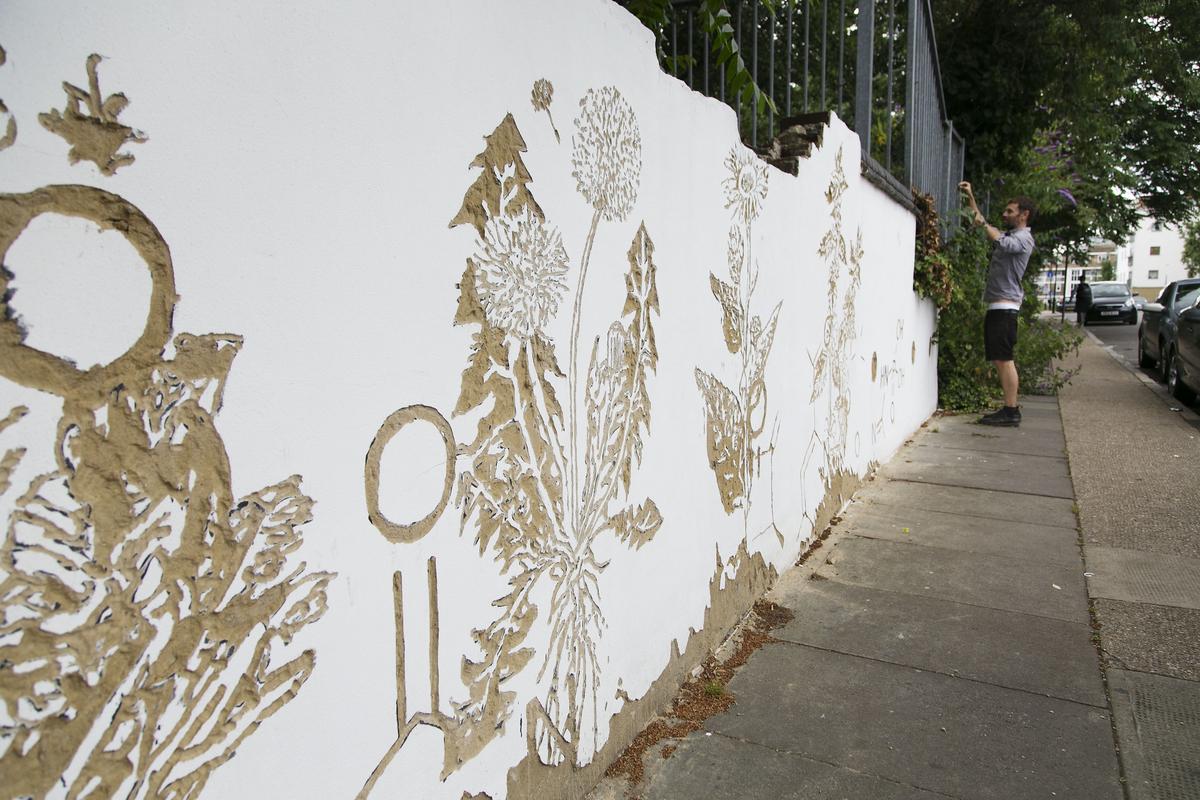 Young man creating wildflower wall art
