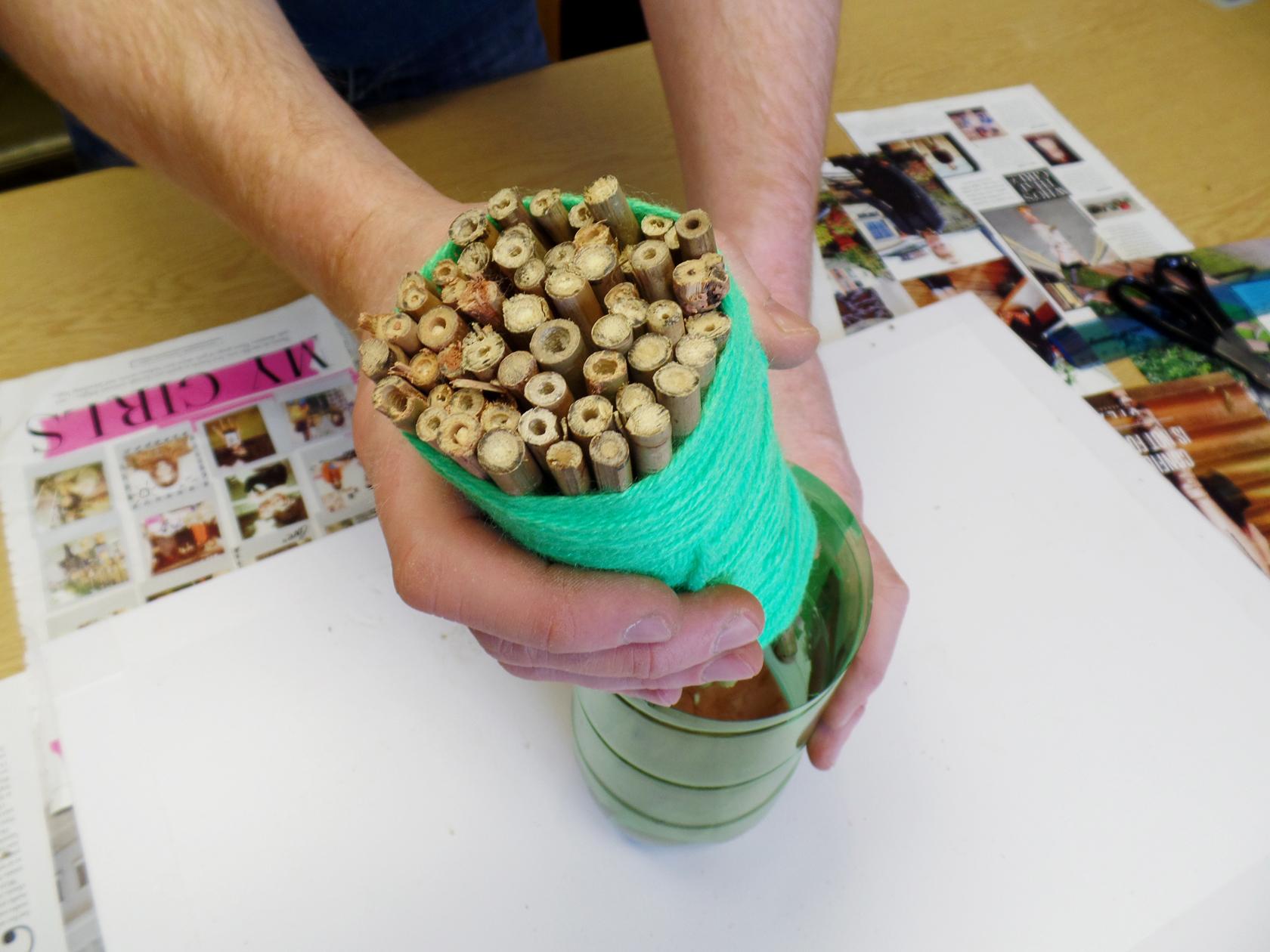 Filling a home-made bee house with bamboo Filling a home-made bee house with bamboo
